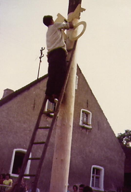 Petersbaumaufstellung 1967: Nach erfolgter Aufrichtung des Baumes werden die Schlüssel als Attribut des hl. Petrus angebracht.
